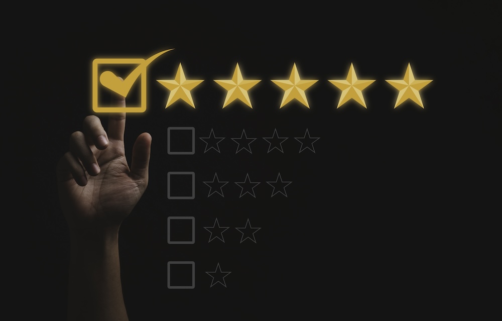 Hand touching and doing mark to five yellow stars on black background, the best customer satisfaction and evaluation for good quality product and service.